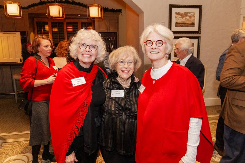 Three GVSU FIrst Ladies, Marcia Haas, Nancy Lubbers, and Elizabeth Murray, standing together and posing for camera